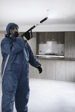 Certified meth decontamination technician spraying treatment inside a residential property.